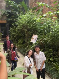 a group of 4 students walking on a path of greenery leaves class together