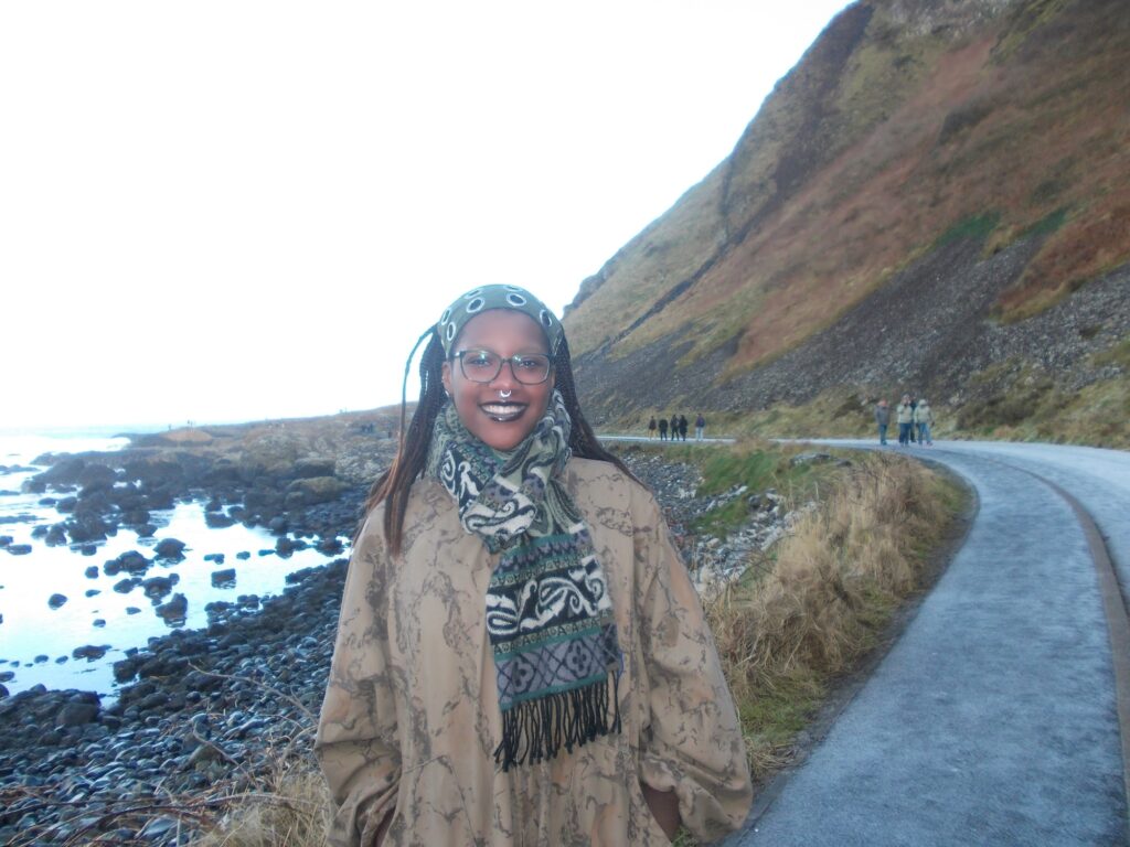 a young woman smiles at the north coast in northern ireland