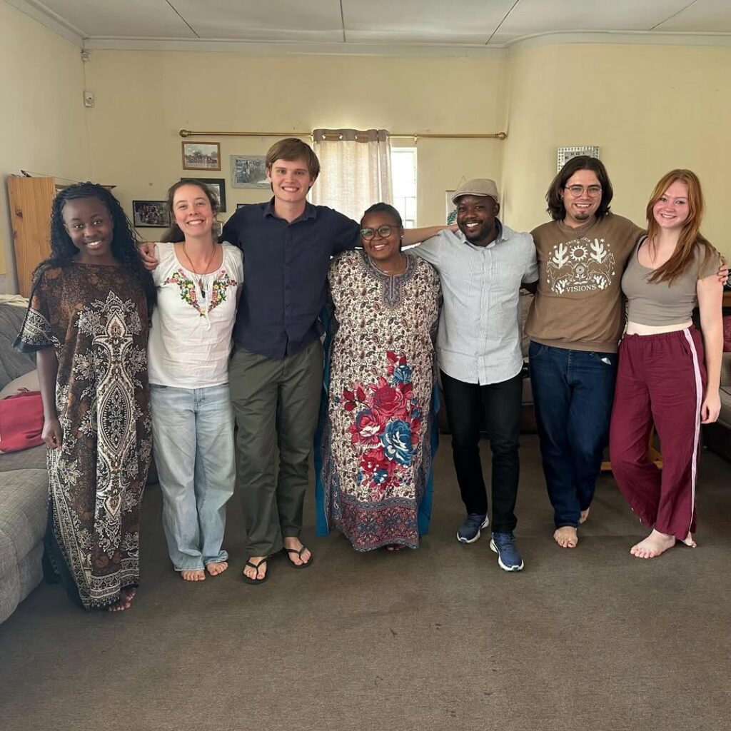 College students stand arm in arm smiling