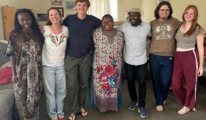 College students stand arm in arm smiling