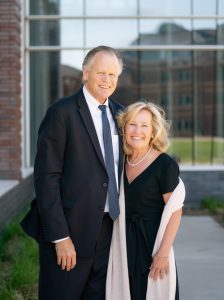 Jeff and Becky Nodland pose outside of building while smiling in formal attire