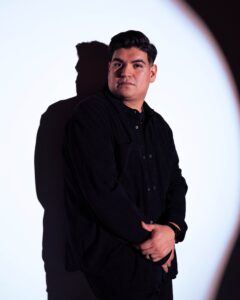 Cristian standing in front of white wall.