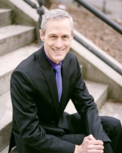 Ross sitting on stairs smiling