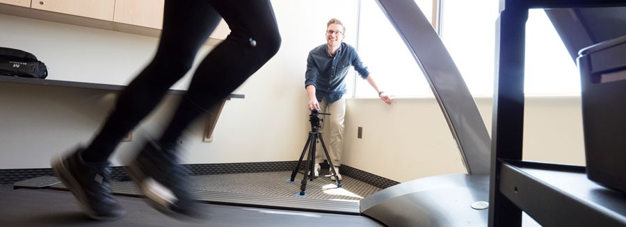 student filming someone running on a treadmill