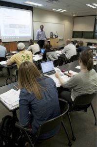 Class listening to a professor lecture with slides