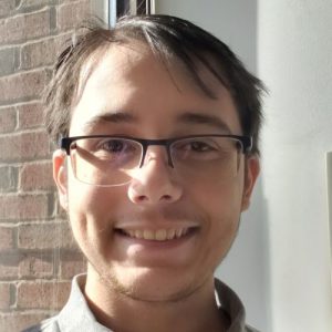 Man in glasses in front of a window