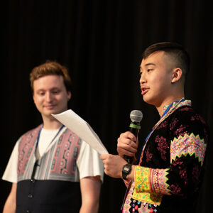 Two students standing on stage making a speech.