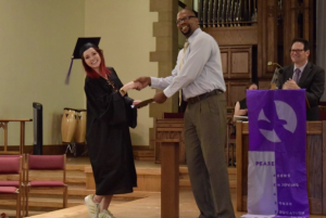 Abbey Ulrich smiling and receiving an award or certificate at Hoversten Chapel