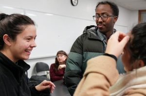 Three Students having a conversation in a classroom 