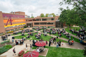 Students eat lunch after Opening Convocation in the Augsburg quad under a cloudy sky.