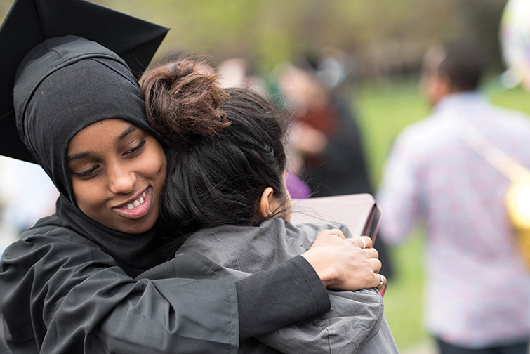 Students hug after a commencement ceremony