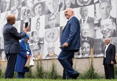 During a break, the 2015 Nobel Peace Prize laureates posed for photos in front of a three-story mural featuring their images along with dozens of other past laureates.