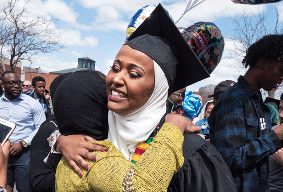 Student embraces family after walking at commencent