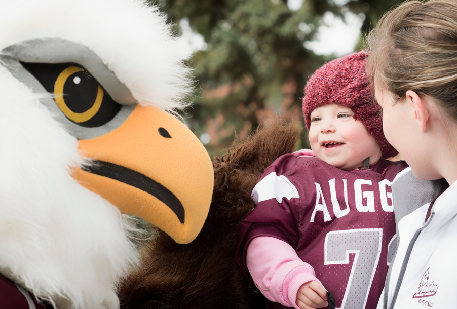 Child enjoys an interaction with Auggie the mascot