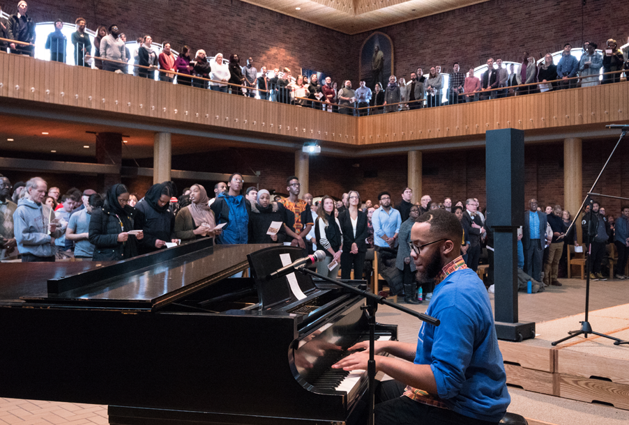 Student plays the piano in front of the crowd at the MLK Convocation