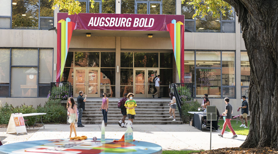 A sign across the balany over the Christensen Center stairs reads Augsburg Bold