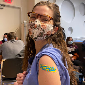 Brittany Kimball with her face mask on and a bandage over where she received a vaccine shot.