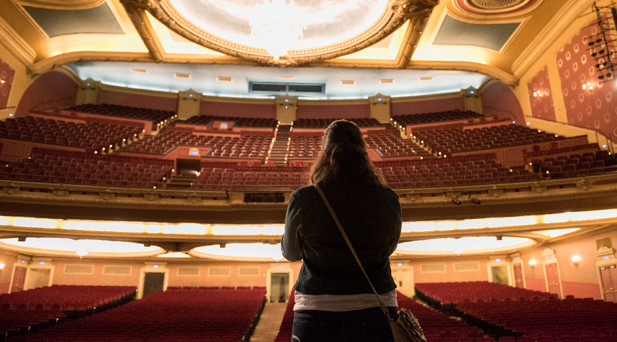 Student looking at the empty seats of a Minneapolis theater