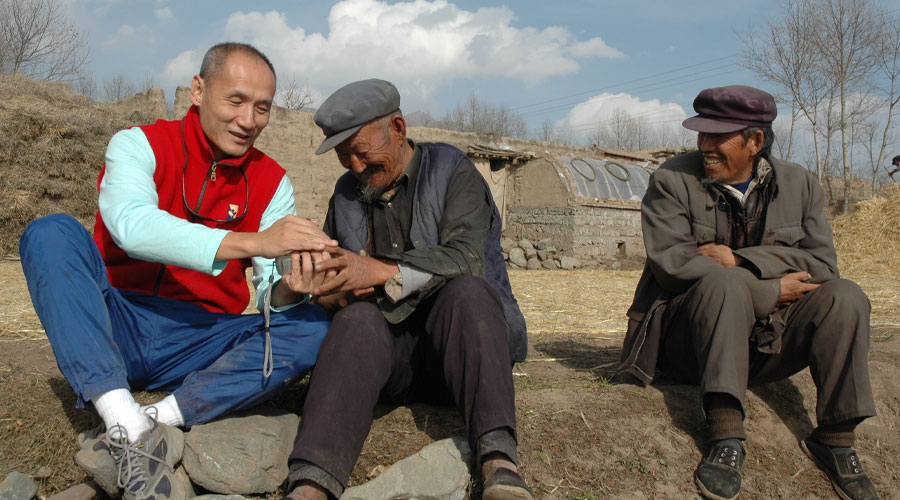 Ray with two others sitting on the ground