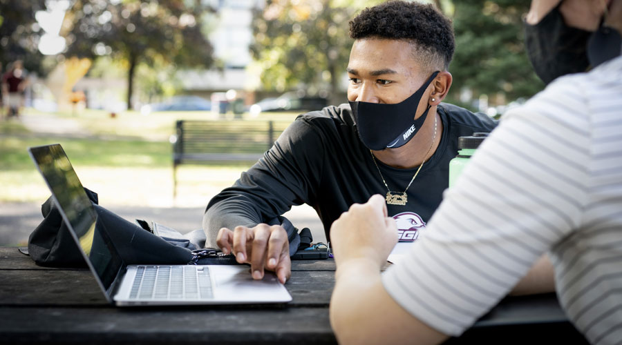 Student with mask on working on his computer