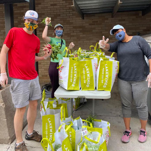 Three people with bags of groceries