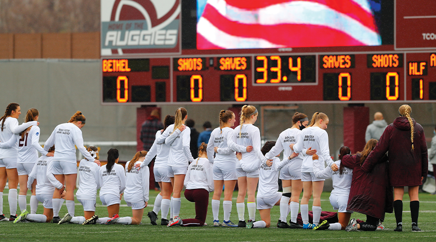 The Augsburg University Women's Soccer team respectfully expressing themselves for the playing of our national anthem