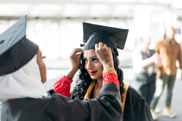 Student getting cap adjusted at commencement