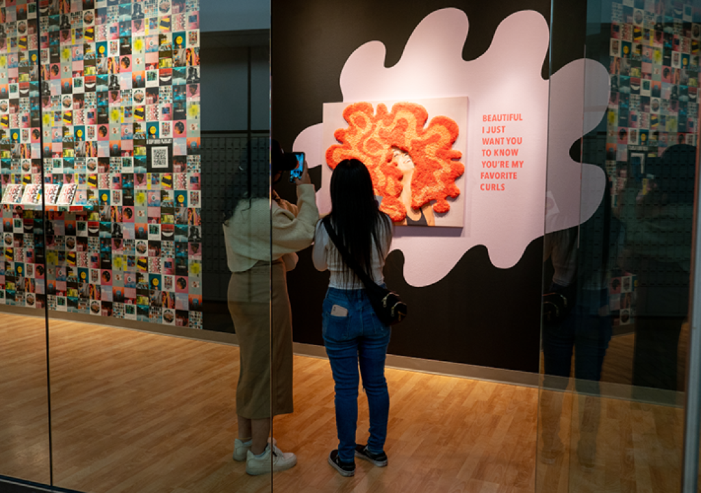 Two people view the artwork in the 