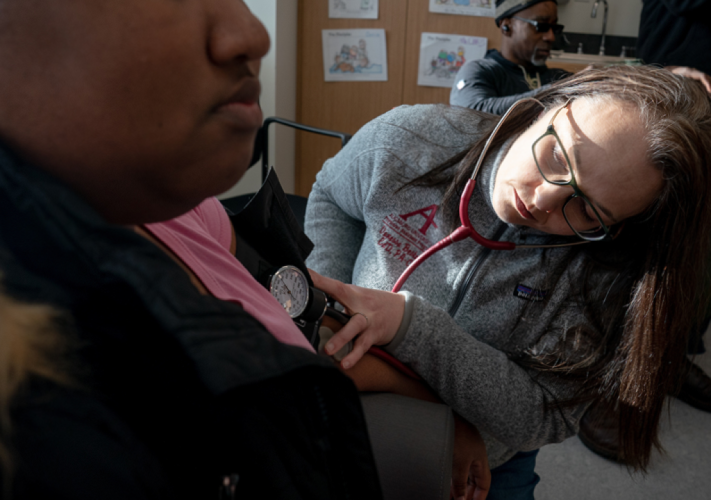 Physician’s Assistant Program Director Vanessa Bester takes a visitor's blood pressure at Augsburg Health Commons.