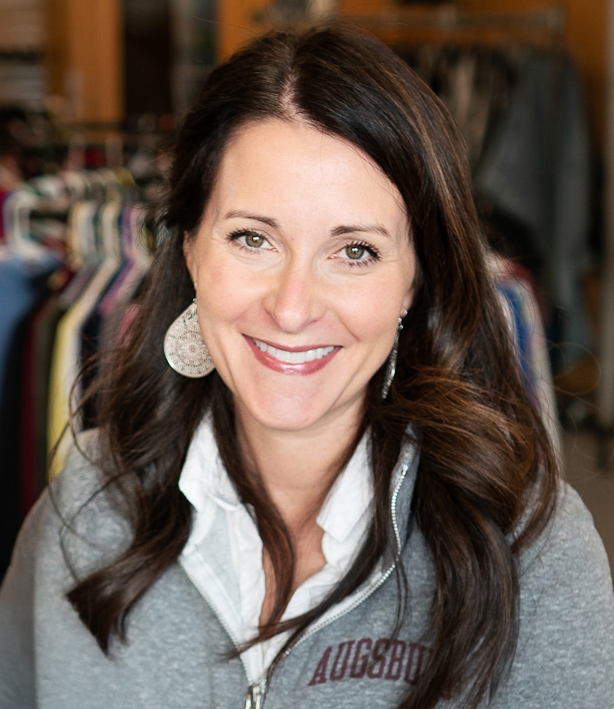 Katie Clark has long dark hair and is wearing a gray Augsburg fleece over a white collared shirt.