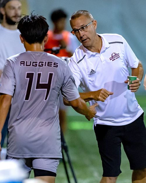 Coach Greg Holder talking to player number 14.