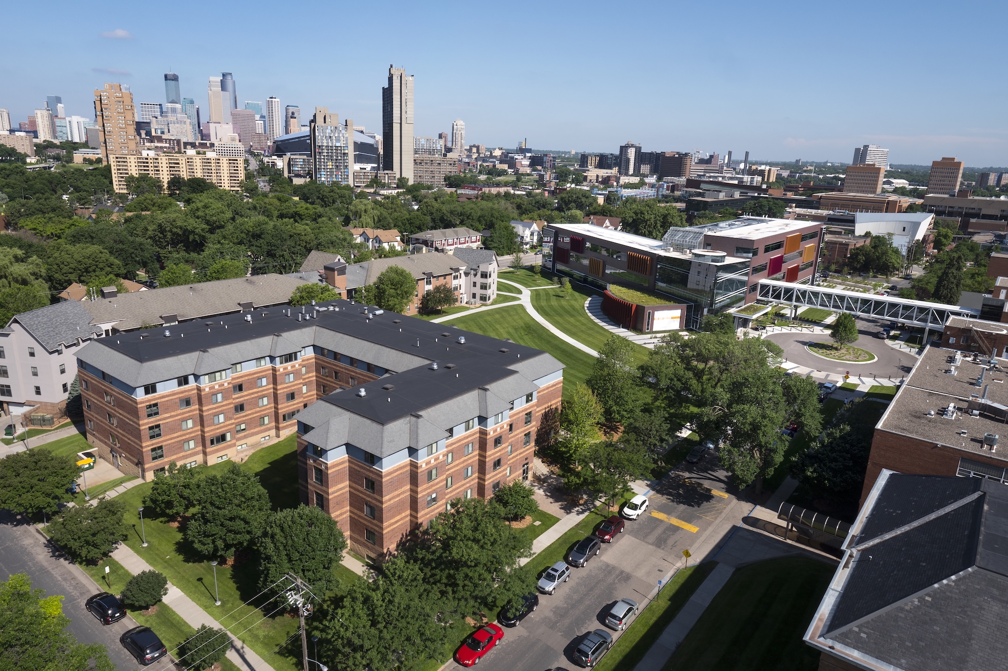 Aerial photo of Augsburg campus with Anderson Hall in the foreground, Minneapolis skyline behind