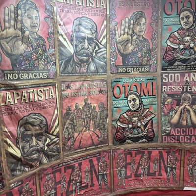 IMG_7389 2 Wall covered with political activist posters featuring Emiliano Zapata and Indigenous resistance motifs.