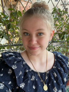 mollie lohmann in a navy blue dress smiling at the camera