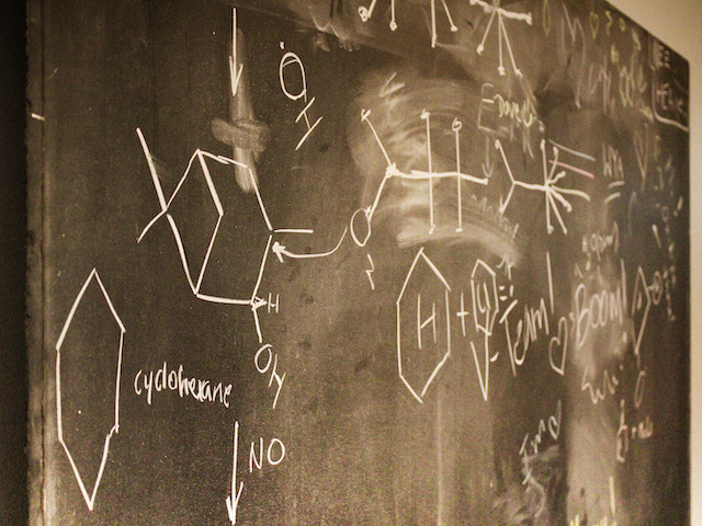 A chalkboard with chemistry drawings and formulas