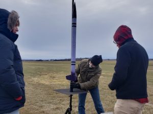 Rocket club in a field outdoors mounting their rocket for launch