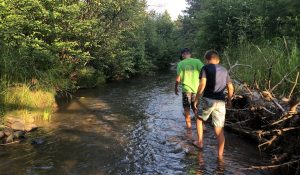 young people walking in a stream