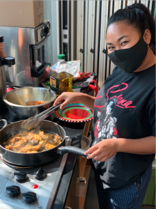 Grace preparing chicken for her Bodo Indian Green Salad