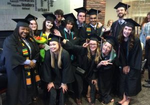 Newly minted sociology majors show how excited they are to have just graduated.