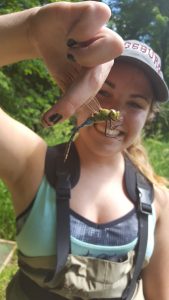 Photo of Holly Kundel holding a dragonfly