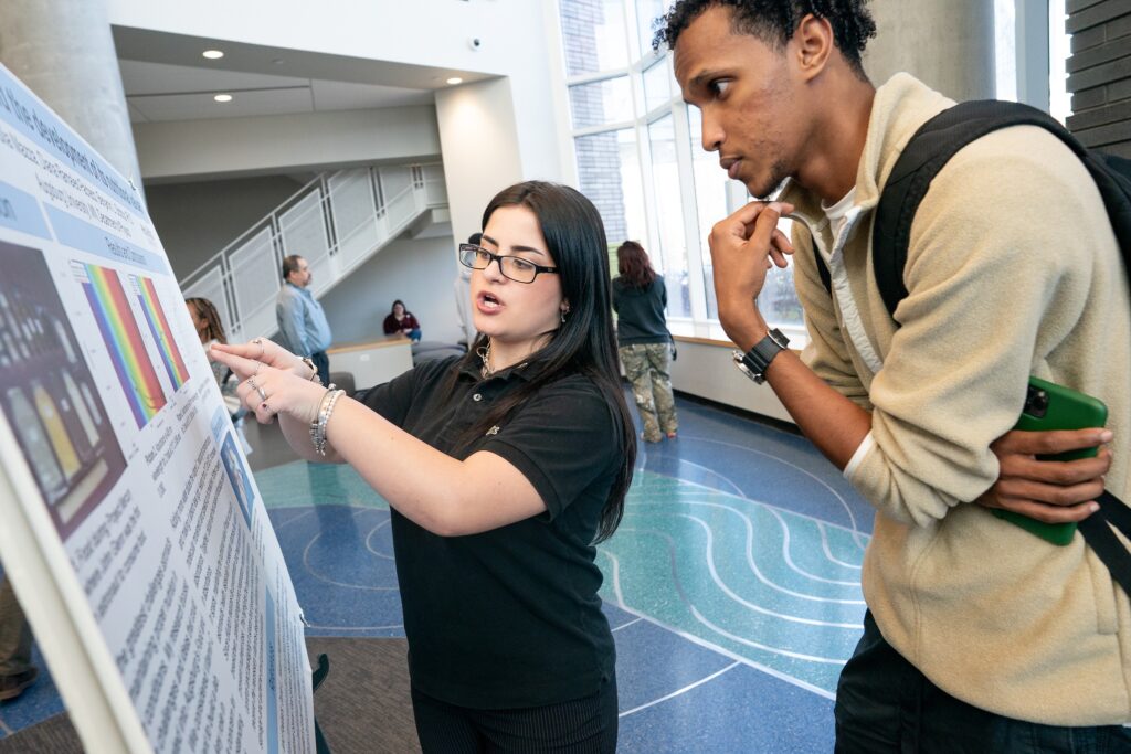 student presenting research to other student at Zyzzogeton 2025